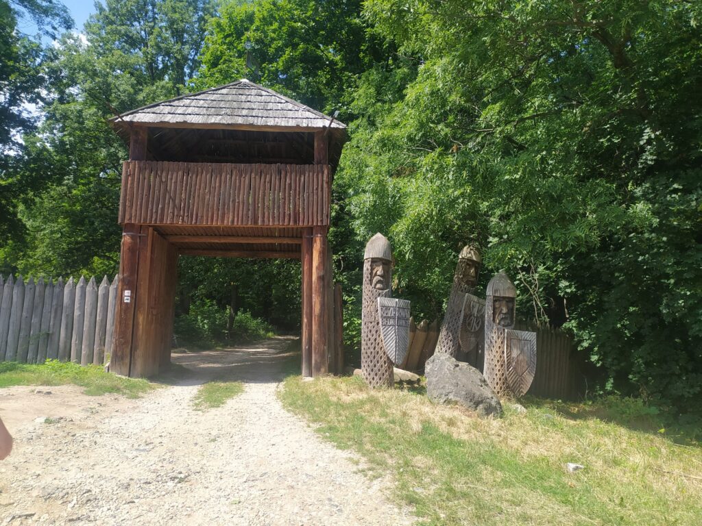 Drewniana brama z rzeźbami przy stanowisku archeologicznym w okolicach Ślęży