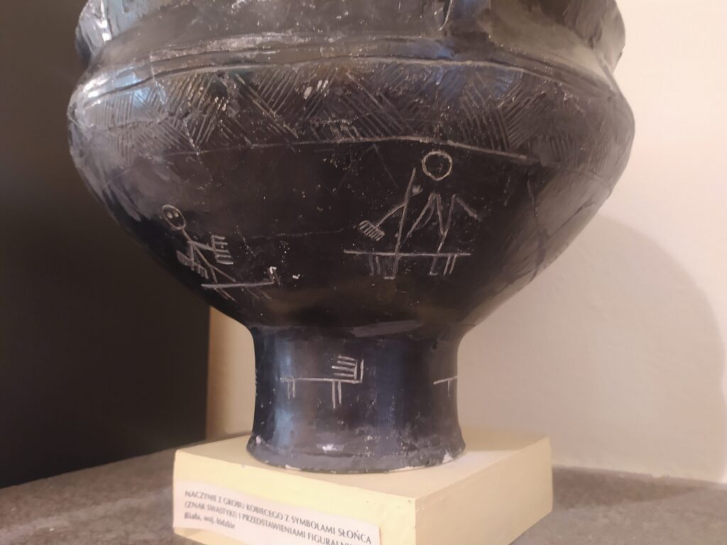 Naczynie ceramiczne z rytymi przedstawieniami postaci na ekspozycji muzealnej
