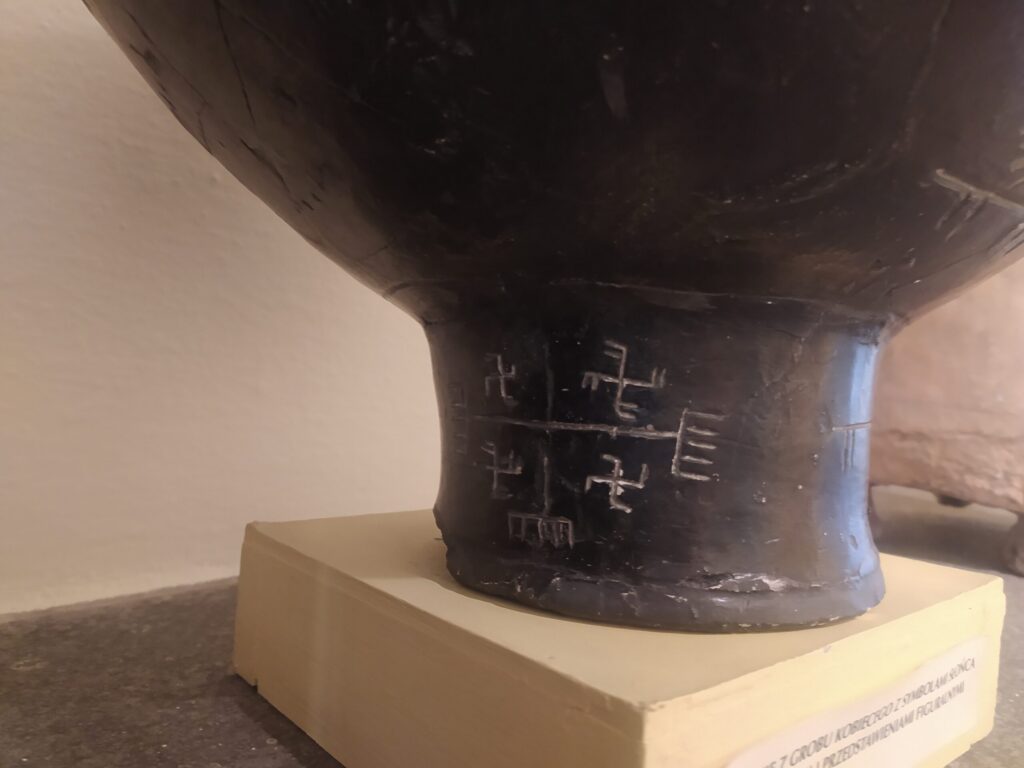 Ryte znaki na dolnej części zabytkowego naczynia ceramicznego