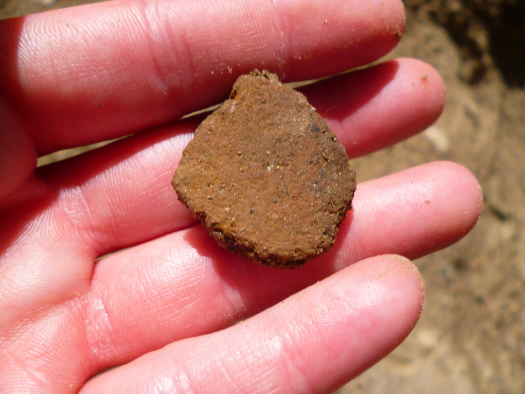 Fragment ceramiki z pomorskiego grodziska pokazany na dłoni